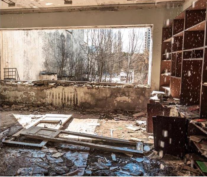 Water dripping from ceiling, building damaged by fire and water, mud on floor debris on floor