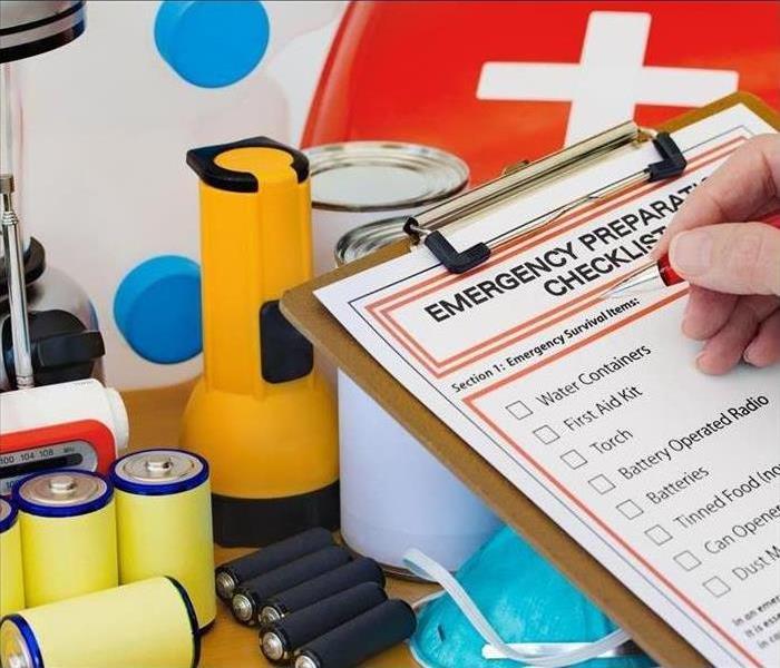 List on a clipboard, batteries, flashlights, radio, gallons of water